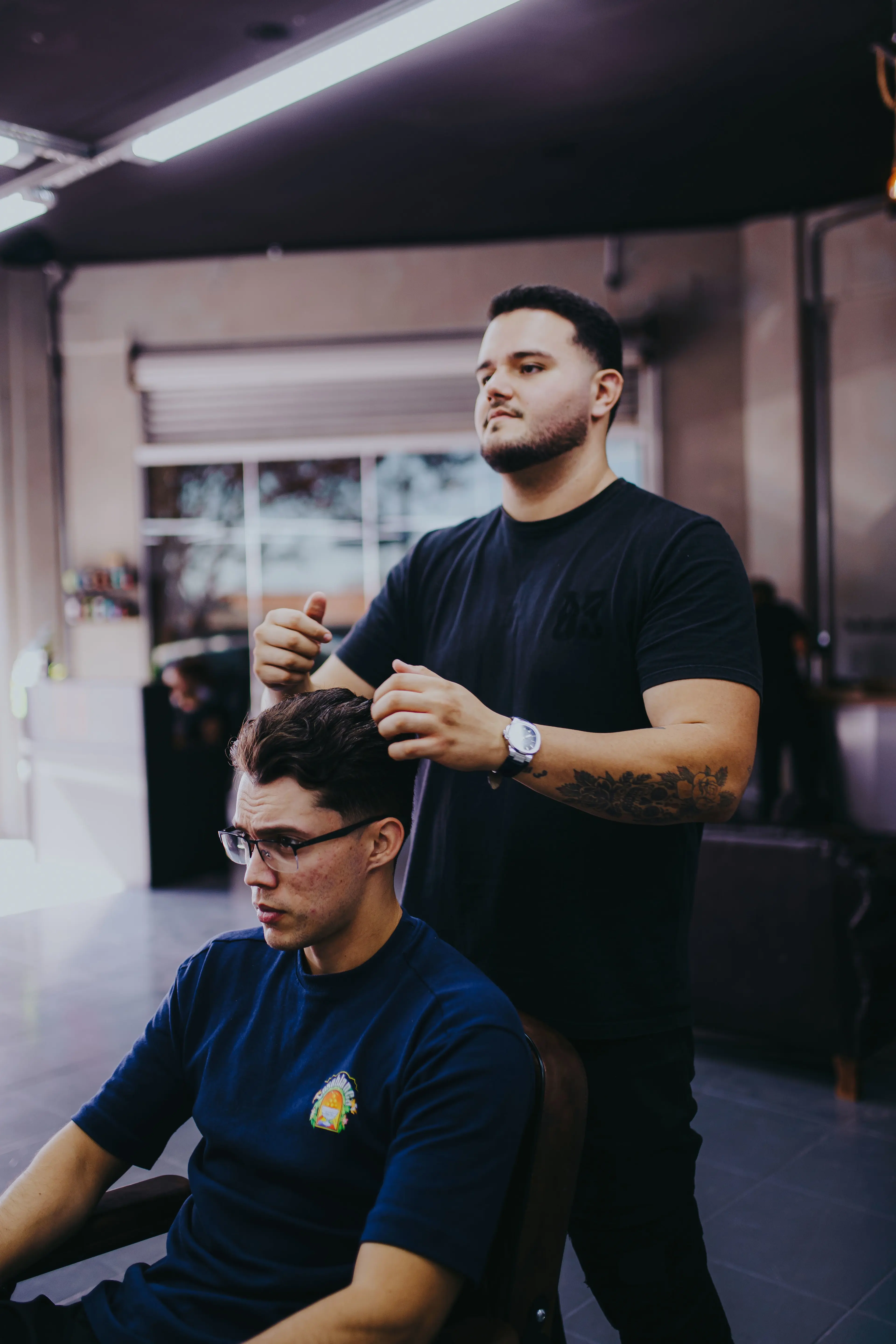 Barbeiro finalizando um corte na Barbearia Kings