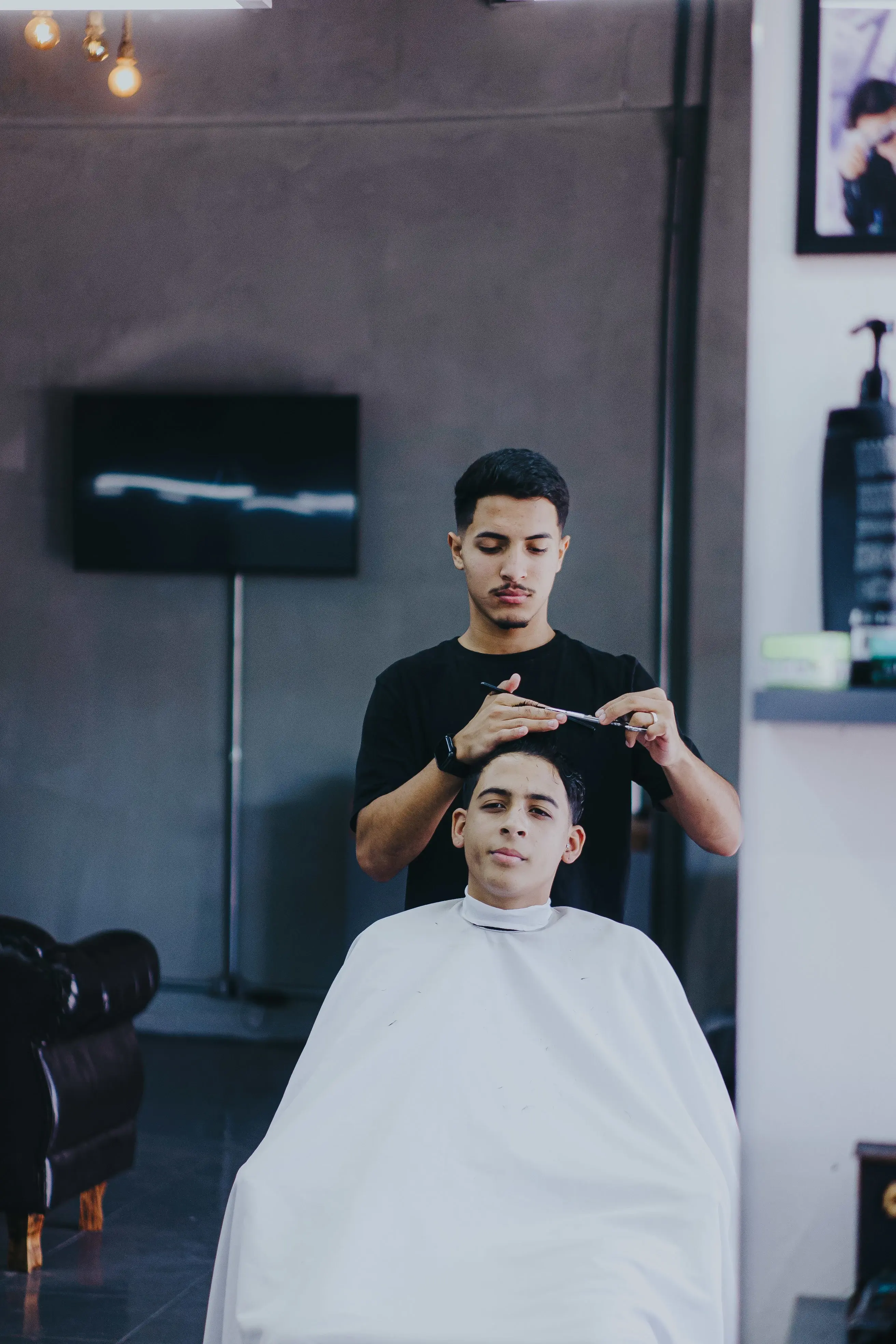 Barbeiro trabalhando com tesoura na Barbearia Kings